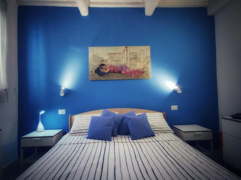 um quarto azul com uma cama com paredes azuis em La Casa di Adele em Porto SantʼElpidio