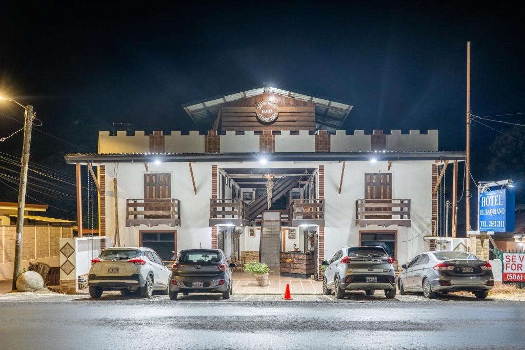 eine Gruppe von Autos, die vor einem Gebäude geparkt sind in der Unterkunft Hotel El Baquiano in Tamarindo