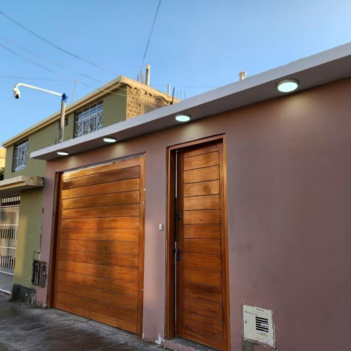 a pair of wooden garage doors on a building at La casa de Teo in Ica