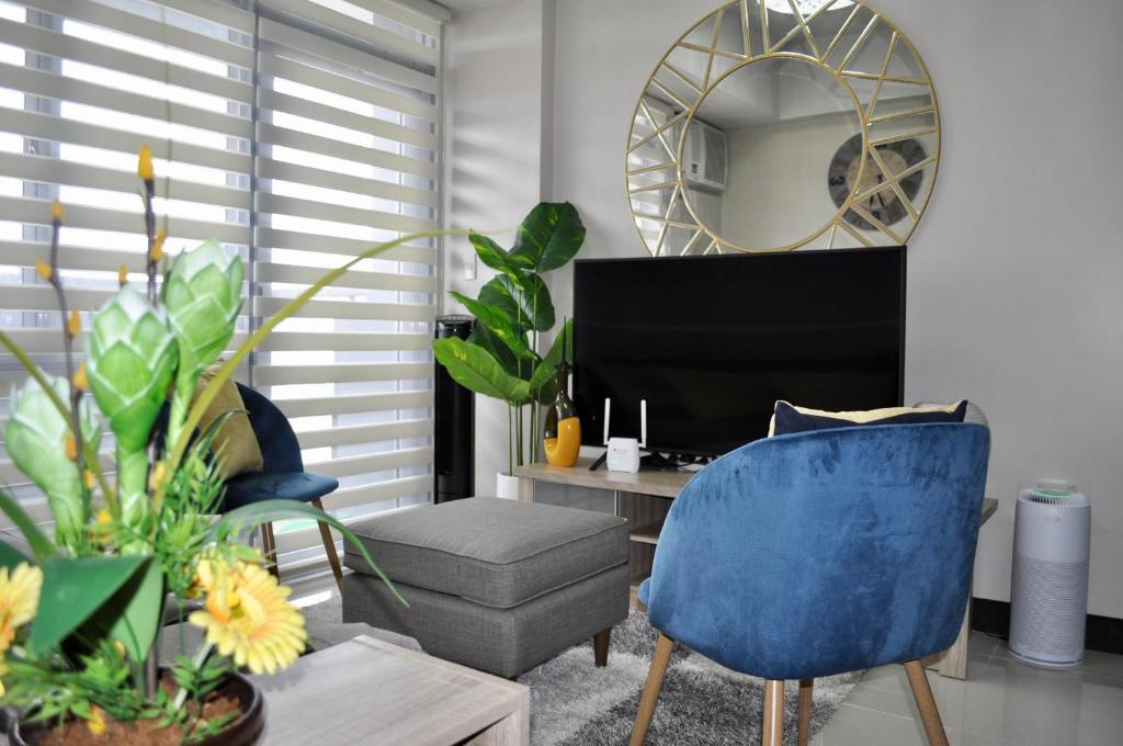 a living room with a blue chair and a mirror at Casa De Camelina in Manila