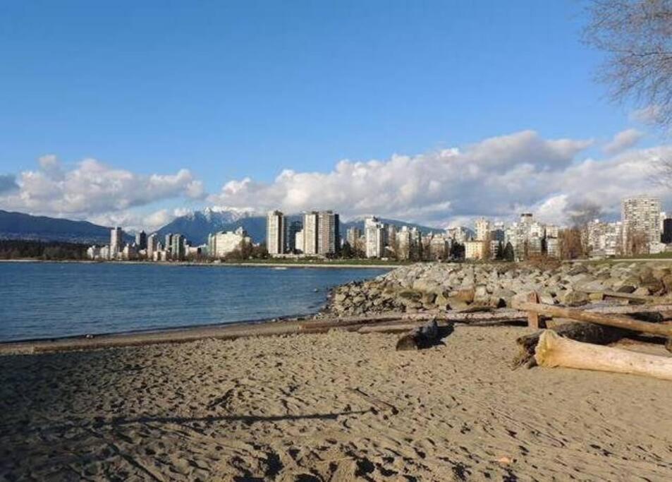 a sandy beach with a city in the background at Kitsilano Beach Executive Condo in Vancouver
