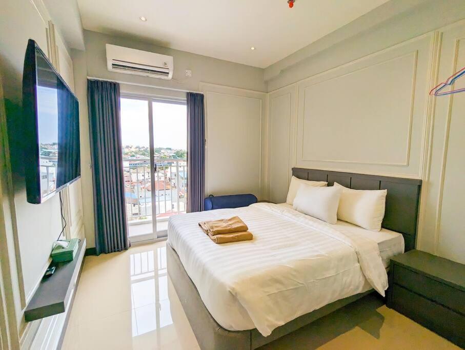 een slaapkamer met een groot bed en een raam bij Lovina 8-25 @Citra Plaza Nagoya in Nagoya