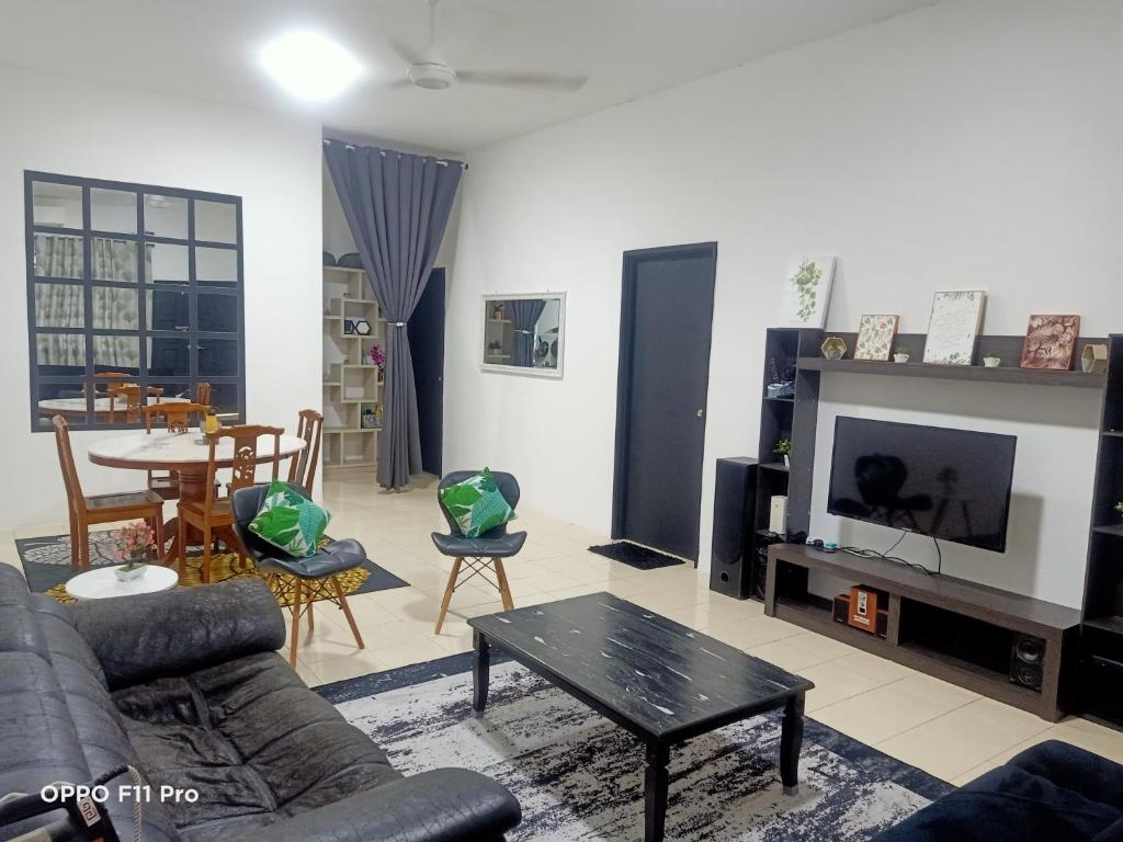 uma sala de estar com um sofá e uma mesa em Homestay Izzauni em Kuantan