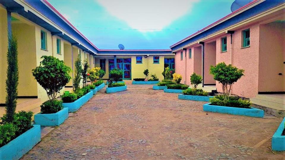 um pátio de uma escola com plantas e árvores em Wayu Nova Guesthouse em Bulbula