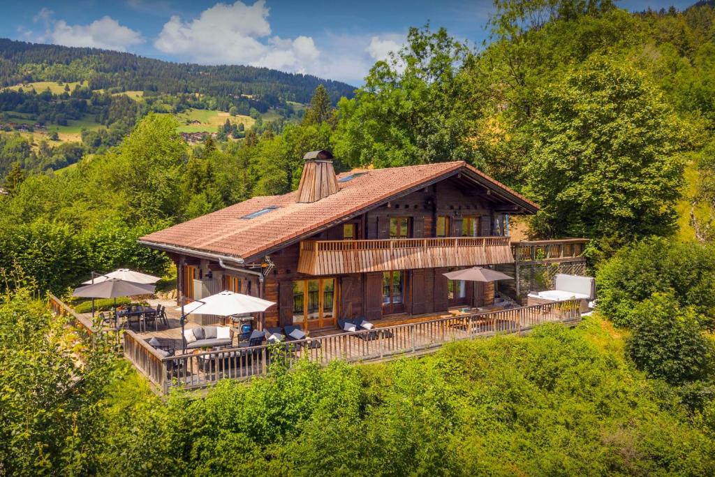 a large wooden house on top of a hill at Chalet Morclan - OVO Network in Manigod
