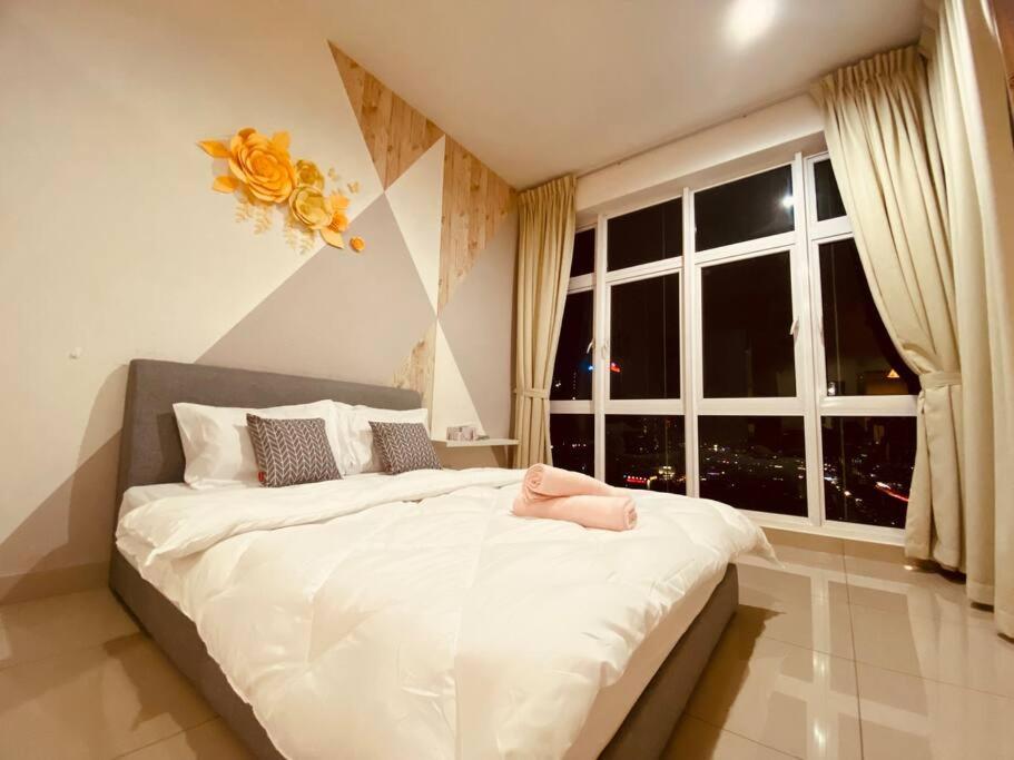 Cette chambre comprend un grand lit blanc et une fenêtre. dans l'établissement Twin Galaxy@B20/City View, à Johor Bahru