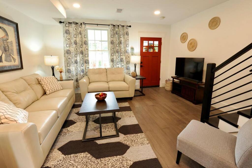 sala de estar con sofá y TV en Cherry Blossom Townhouse, Easy DC Access, en Washington