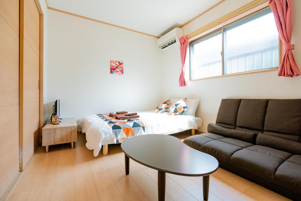 a living room with a bed and a couch at Ferio101 in Tokyo