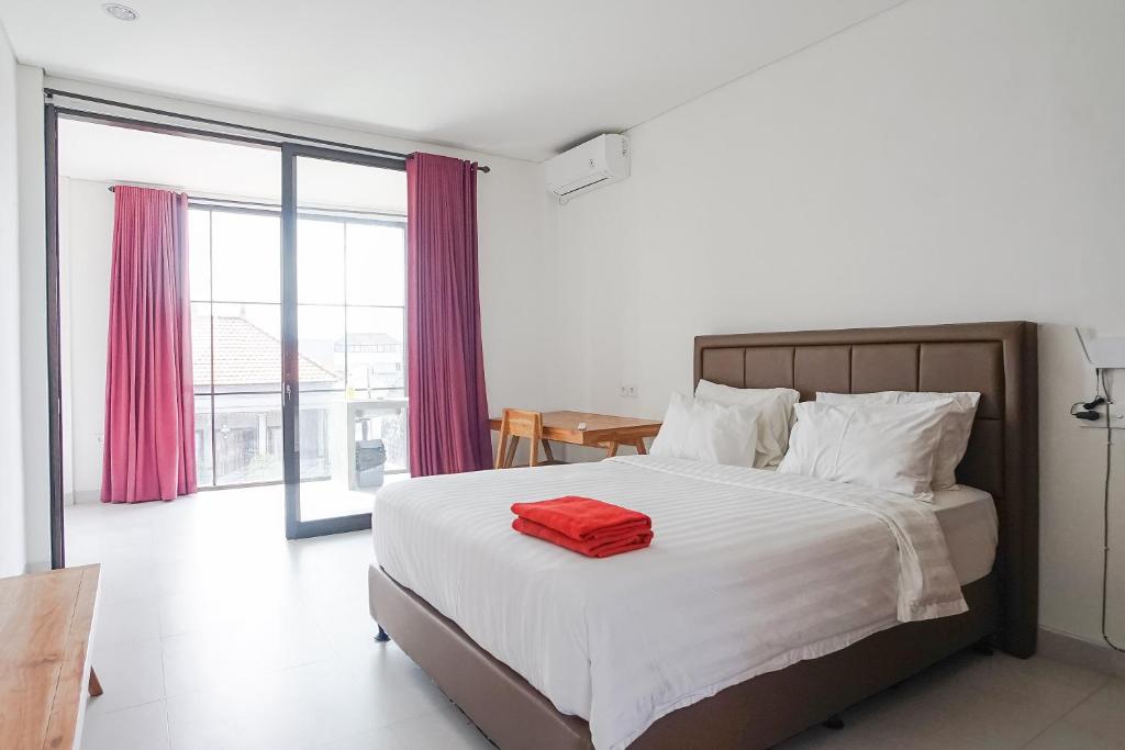 a bedroom with a bed with a red towel on it at Margarita Apartment and Coworking Canggu in Canggu