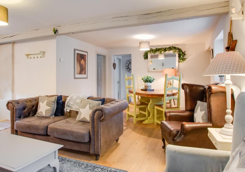 a living room with two couches and a table at Woodpecker Cottage in Pateley Bridge