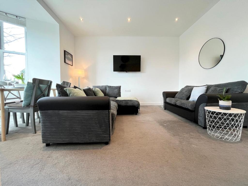 a living room with two couches and a table at Spacious Apartment~Parking~Close to Seafront in Penzance