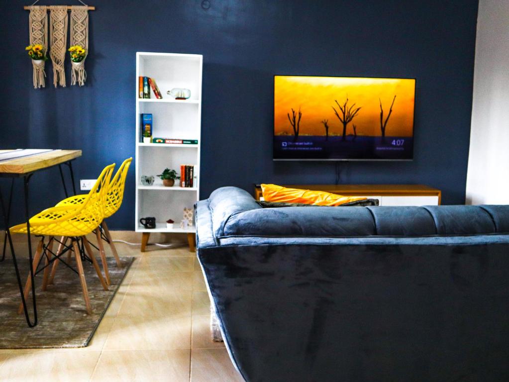 a living room with a blue couch and a yellow chair at Stunning 1-Bedroom Apartment in Madaraka Estate, Nairobi in Nairobi