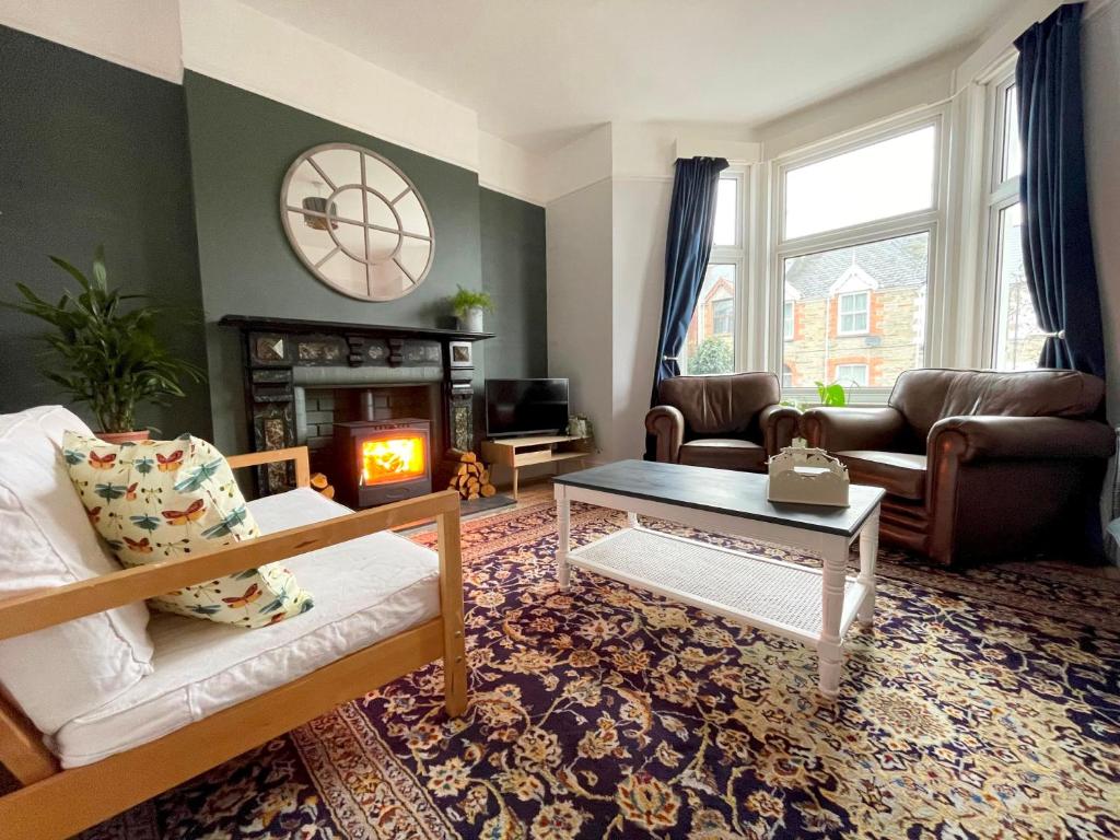 a living room with a couch and a fireplace at Bright & Spacious Edwardian Townhouse with Garden in Truro
