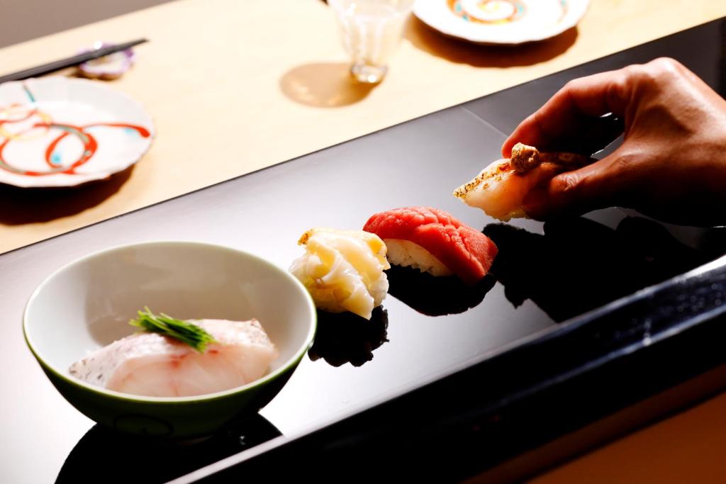 a plate of sushi and a bowl of soup at Hotel Nikko Kanazawa in Kanazawa