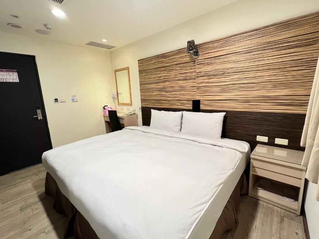 Postel nebo postele na pokoji v ubytování Kaishen Hotel