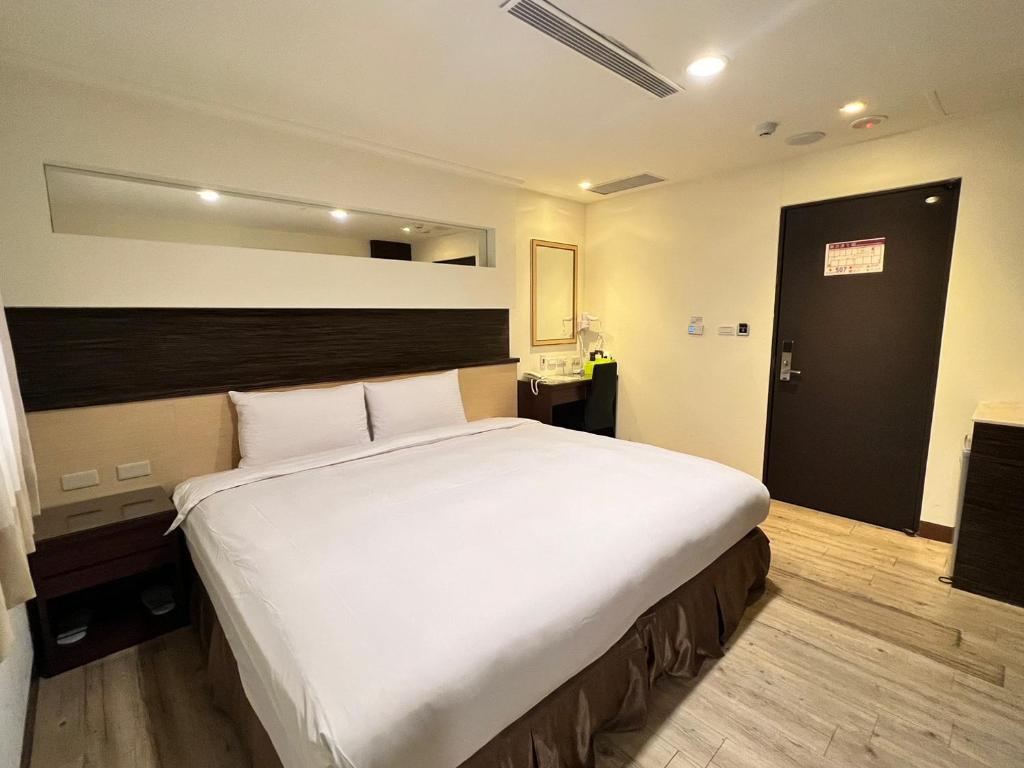 Postel nebo postele na pokoji v ubytování Kaishen Hotel