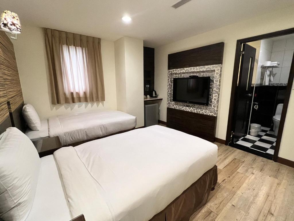Postel nebo postele na pokoji v ubytování Kaishen Hotel
