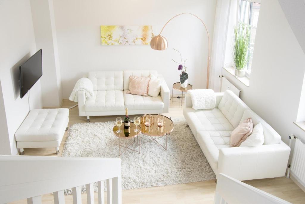 a living room with white furniture and a white couch at Auster in Flensburg
