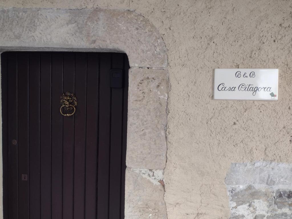 une porte menant à un bâtiment en pierre avec un panneau. dans l'établissement Casa Pitagora, à Pesche