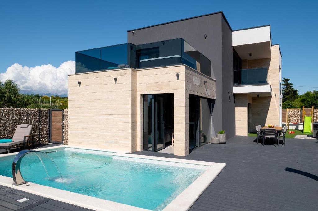 a house with a swimming pool in front of it at Kala in Ražanac