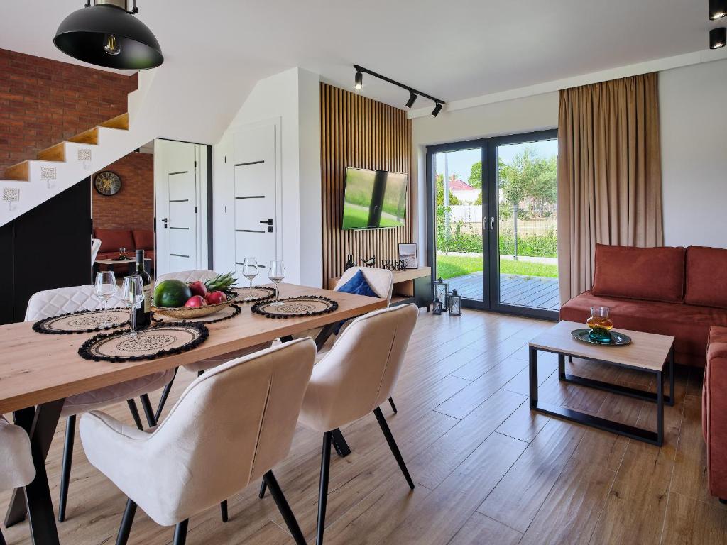 een eetkamer en een woonkamer met een tafel en stoelen bij Apartamenty Marinera in Łeba