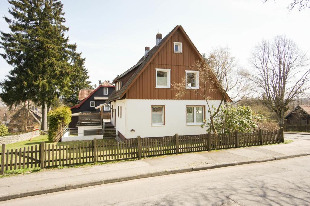 Casa blanca y marrón con valla de madera en Ferienhaus Blocksberg en Braunlage