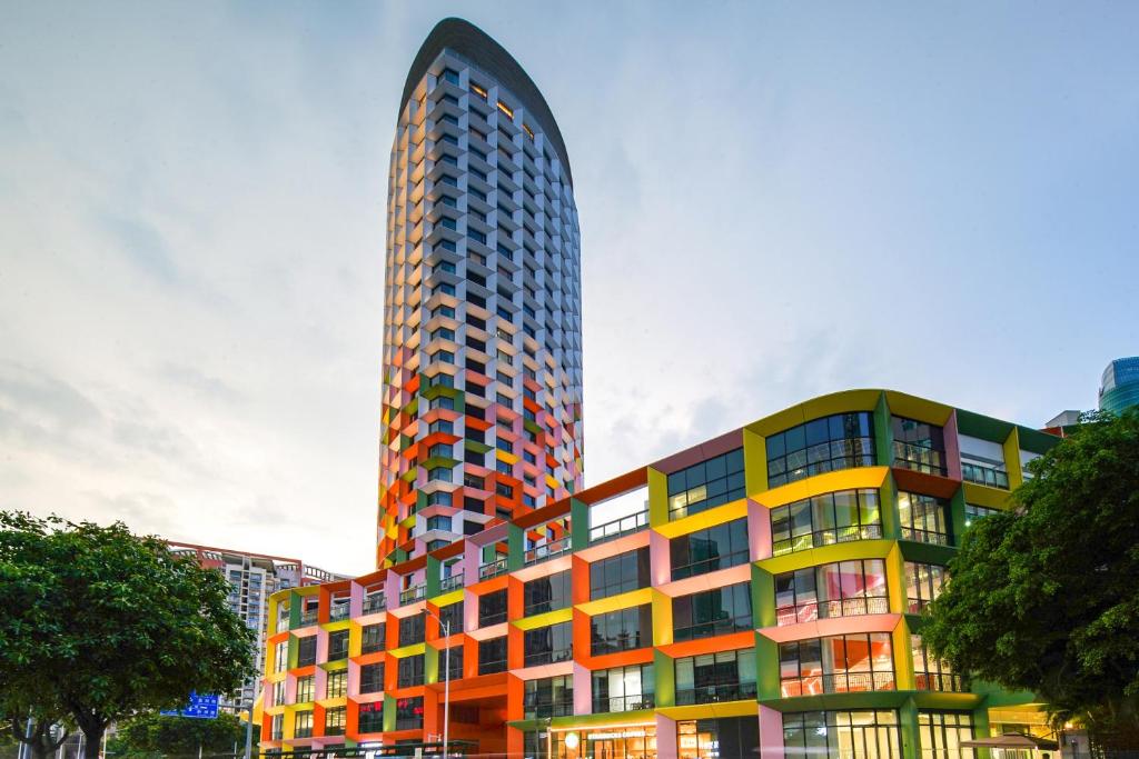 a tall building with a colorful building at Jingju Hotel Shenzhen in Shenzhen