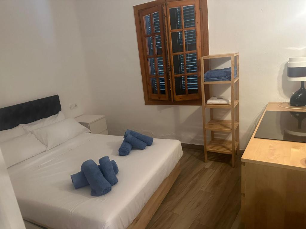 una camera da letto con un letto bianco con cuscini blu di FORNELLS 003 a Es Mercadal