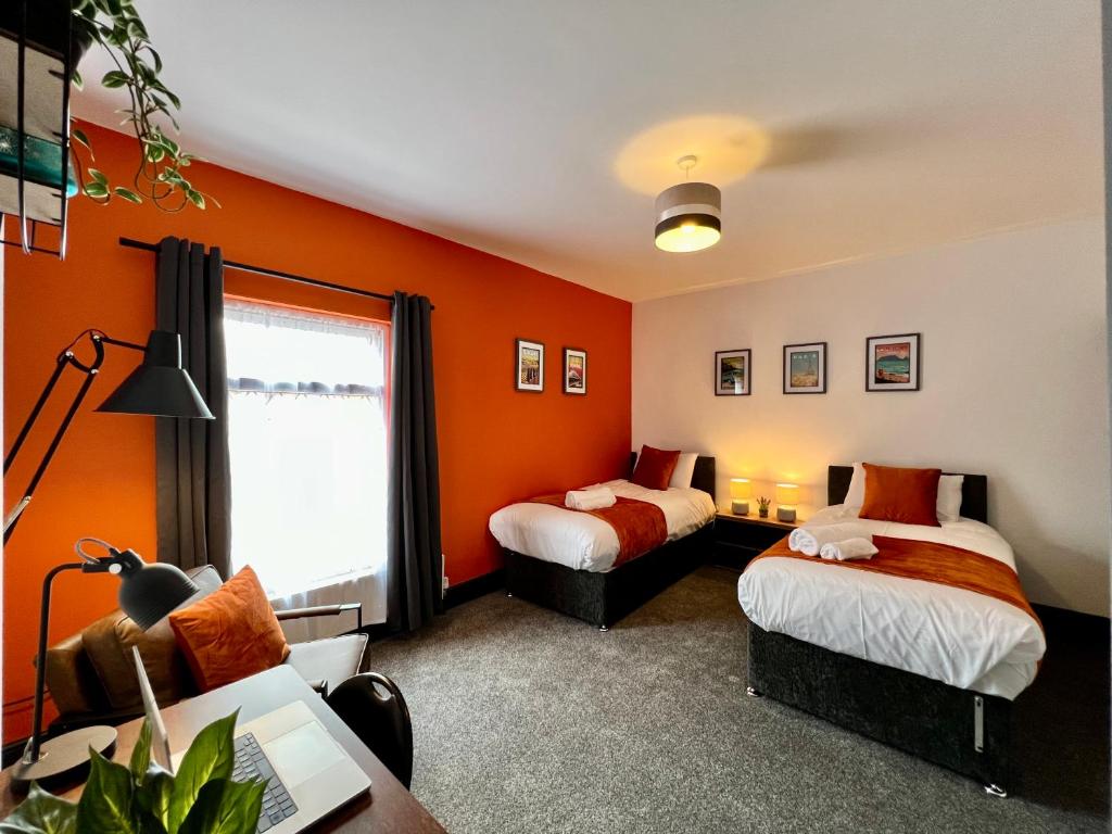- 2 lits dans une chambre aux murs orange dans l'établissement Oxford House - Great for Contractors or Family Holidays, à Cleethorpes