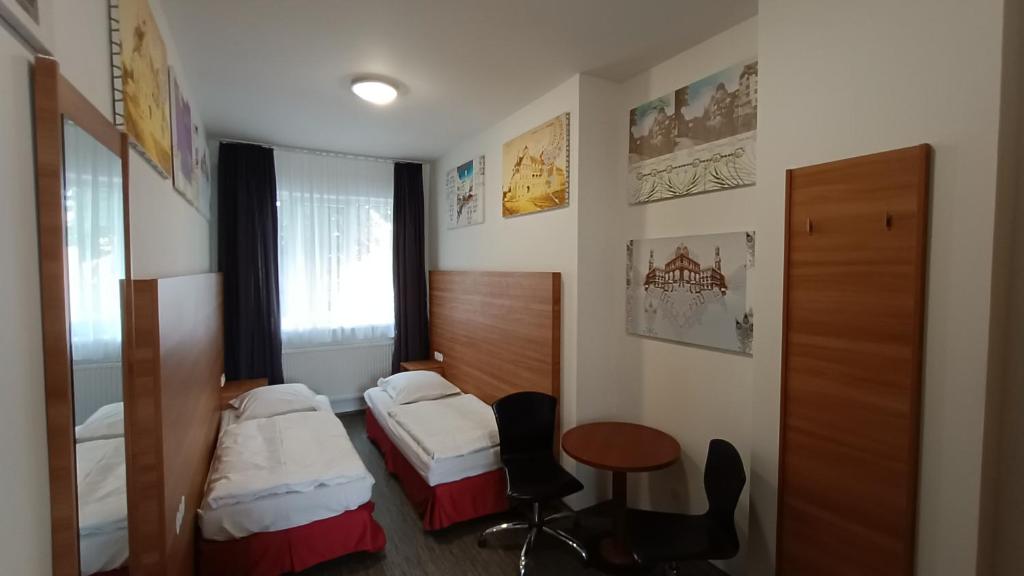 a hotel room with two beds and a table at Apartment Gato in Karlovy Vary