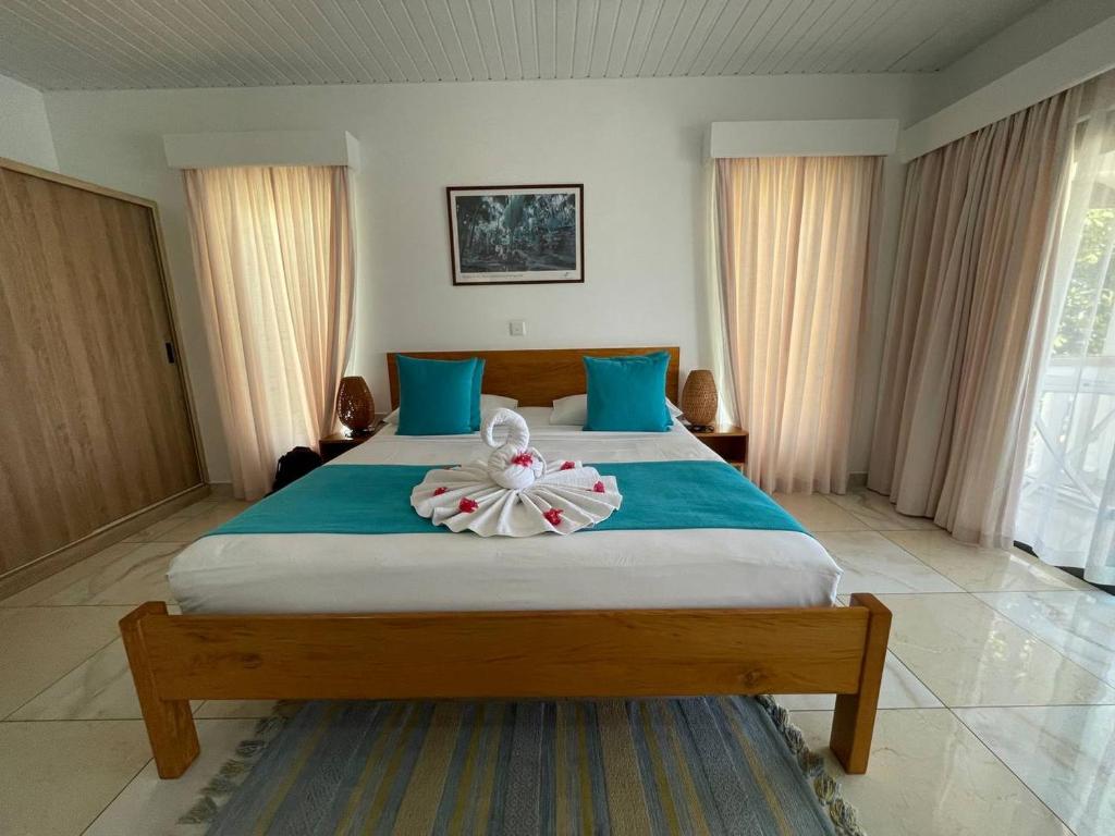 a bedroom with a large bed with towels on it at Marie-France Beach Front Apartments in La Digue