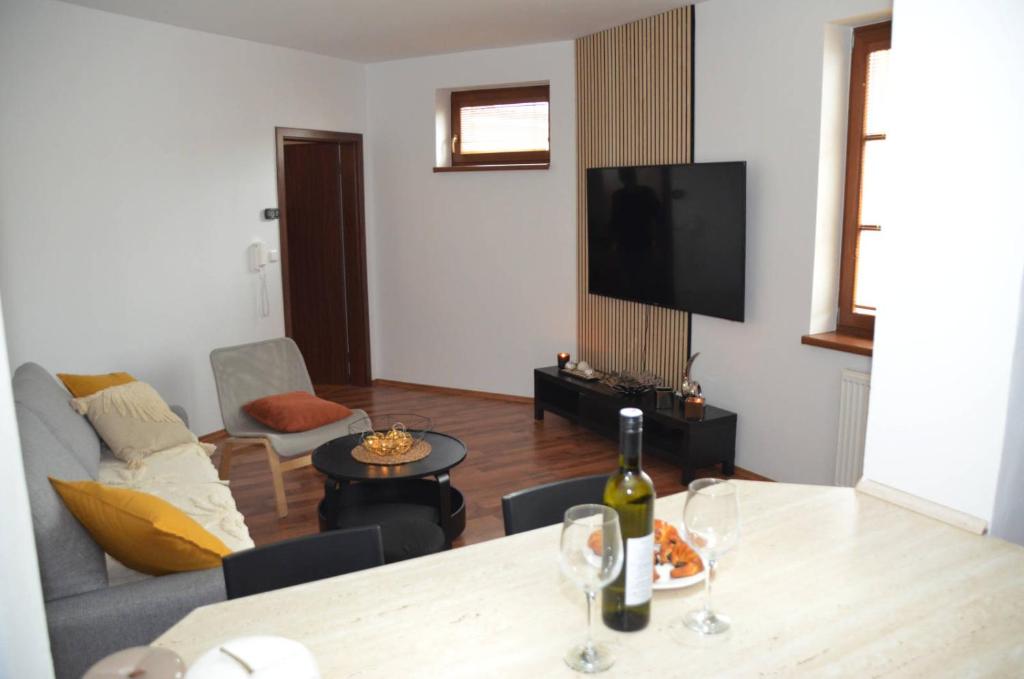 基約夫的住宿－Apartmán U Pepana，客厅配有一张桌子,并提供一瓶葡萄酒