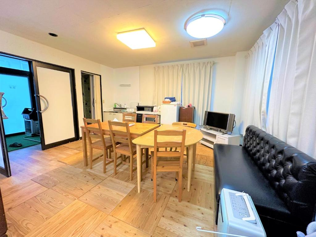 sala de estar con mesa y sofá en Shibasaki House 1F - Vacation STAY 13848, en Kusatsu