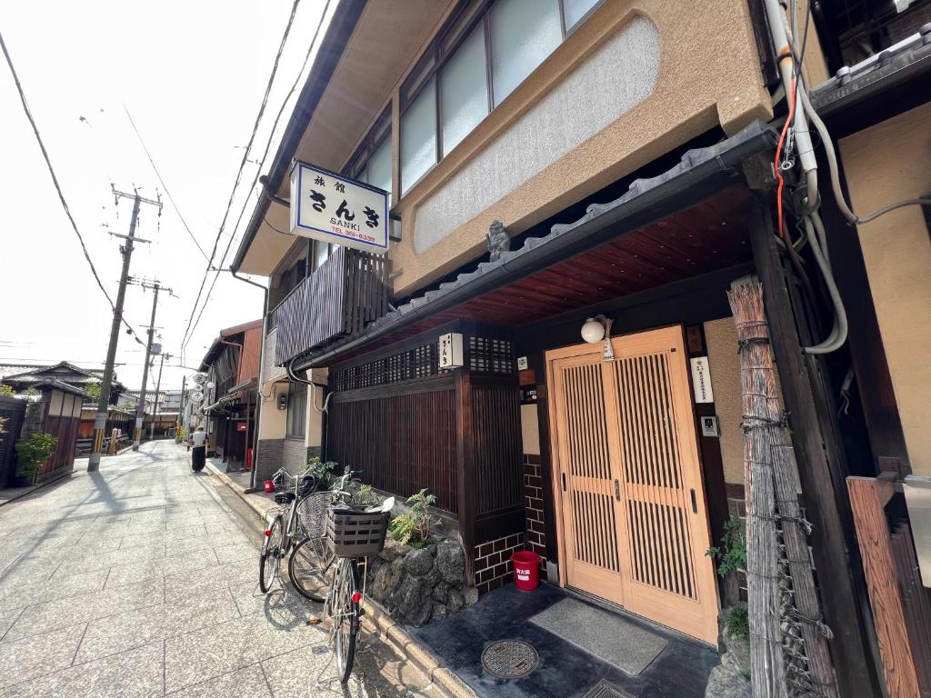 un bâtiment avec un portail et un vélo garé à l'extérieur dans l'établissement Ryokan Sanki, à Kyoto