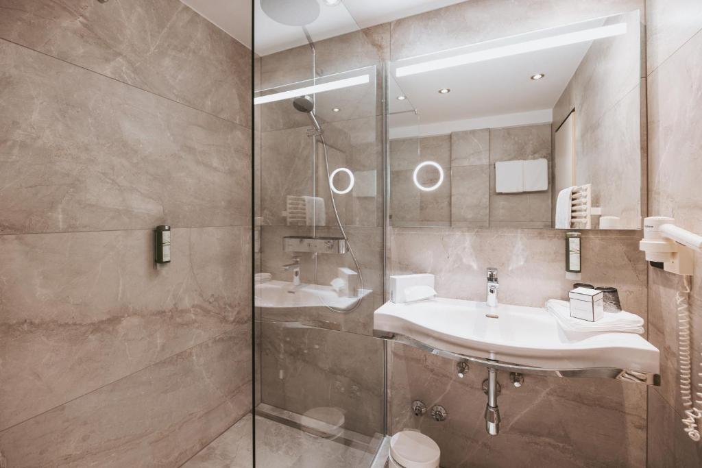 a bathroom with two sinks and a shower at MANNI das Hotel in Mayrhofen