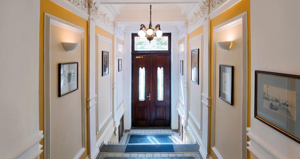 a hallway with a wooden door and a chandelier at Sibelius Apartments in Prague