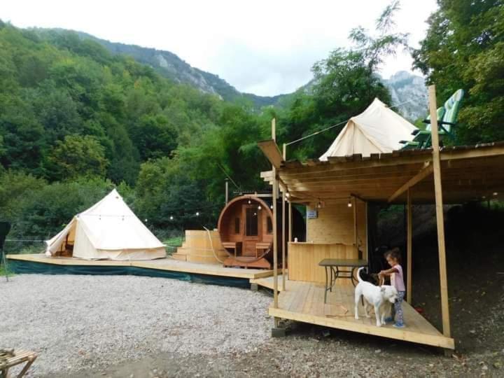 a woman with a dog standing in front of a tent at Tiny House Village Resort 