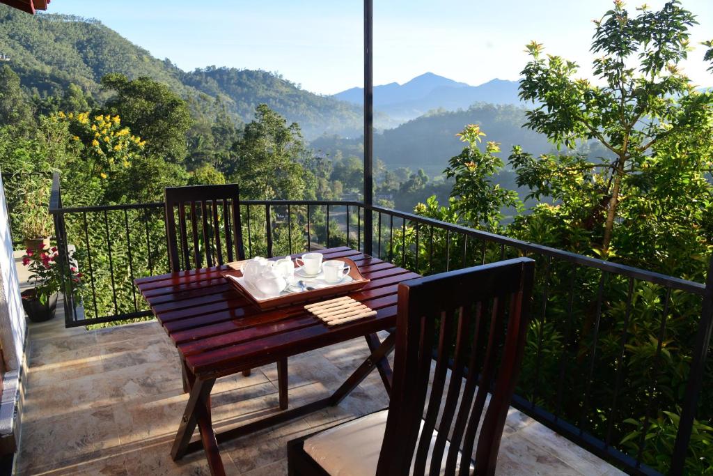 a table on a balcony with a view of the mountains at 9 Hills Ella in Ella