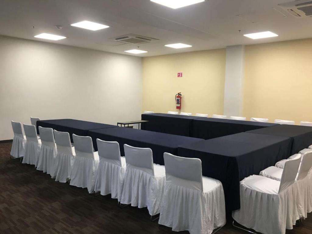 a conference room with a long table and white chairs at Holiday Inn Express Merida Centro by IHG in Mérida