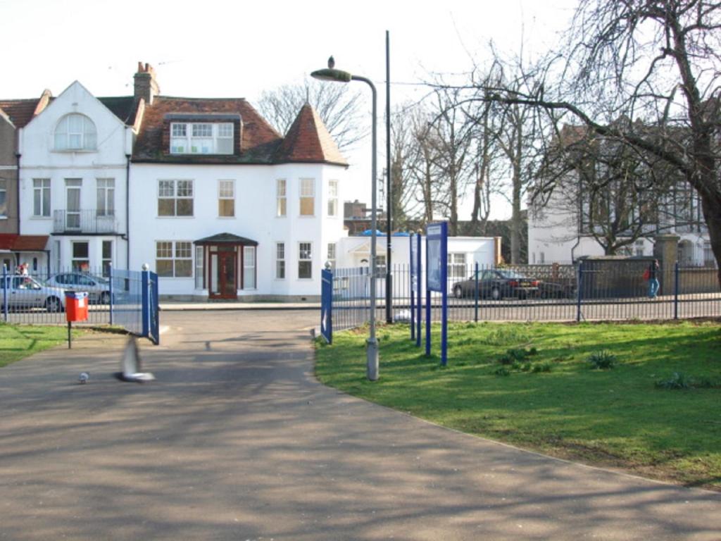 a park with a playground in front of a white house at Apartments close Spurs stadion station 1 minute away in London