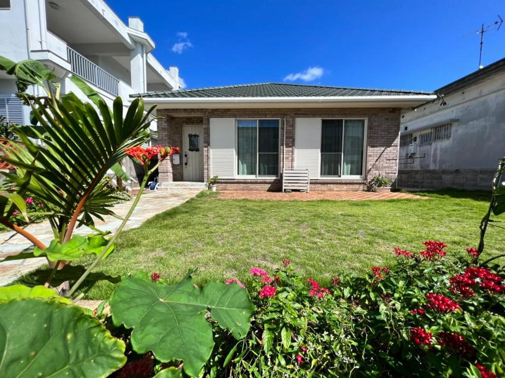 una casa con un patio con flores y plantas en parm tree - Vacation STAY 06171v en Isla Ishigaki