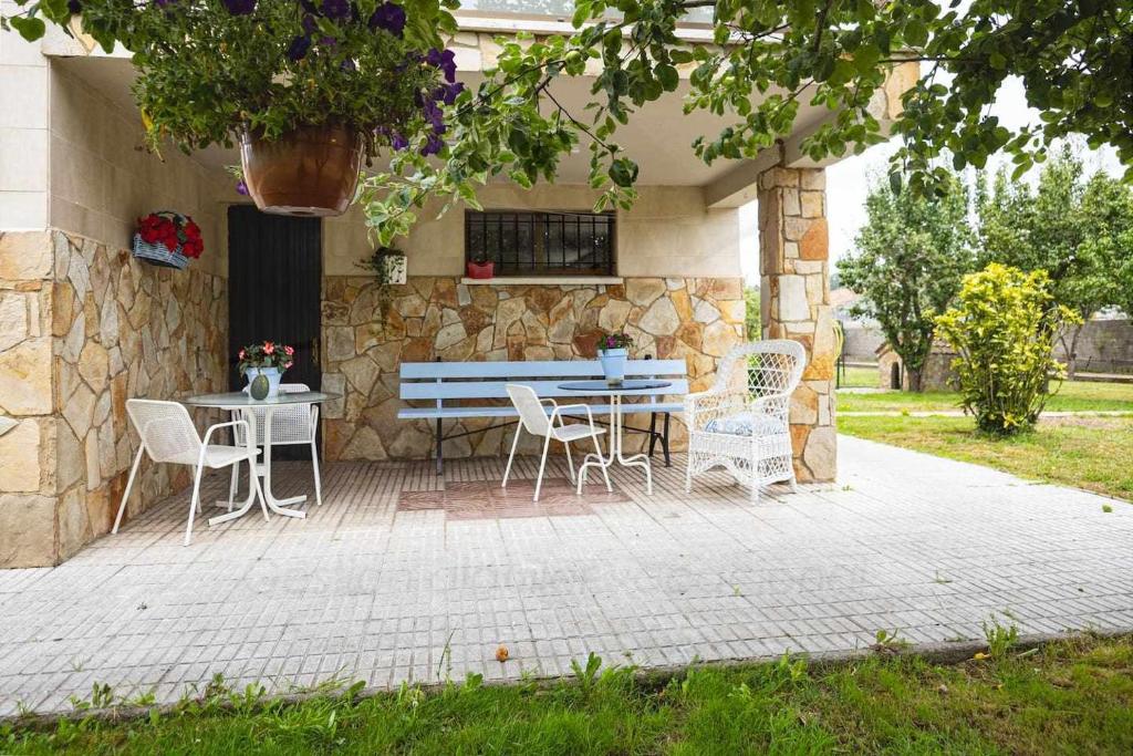 a patio with a blue bench and chairs at La Huertina De Granda in Candanal
