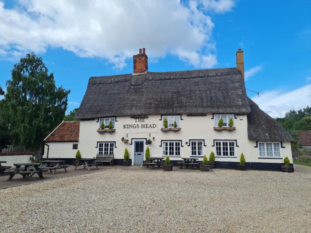 ein weißes Gebäude mit einem Strohdach in der Unterkunft Kings Head in North Lopham