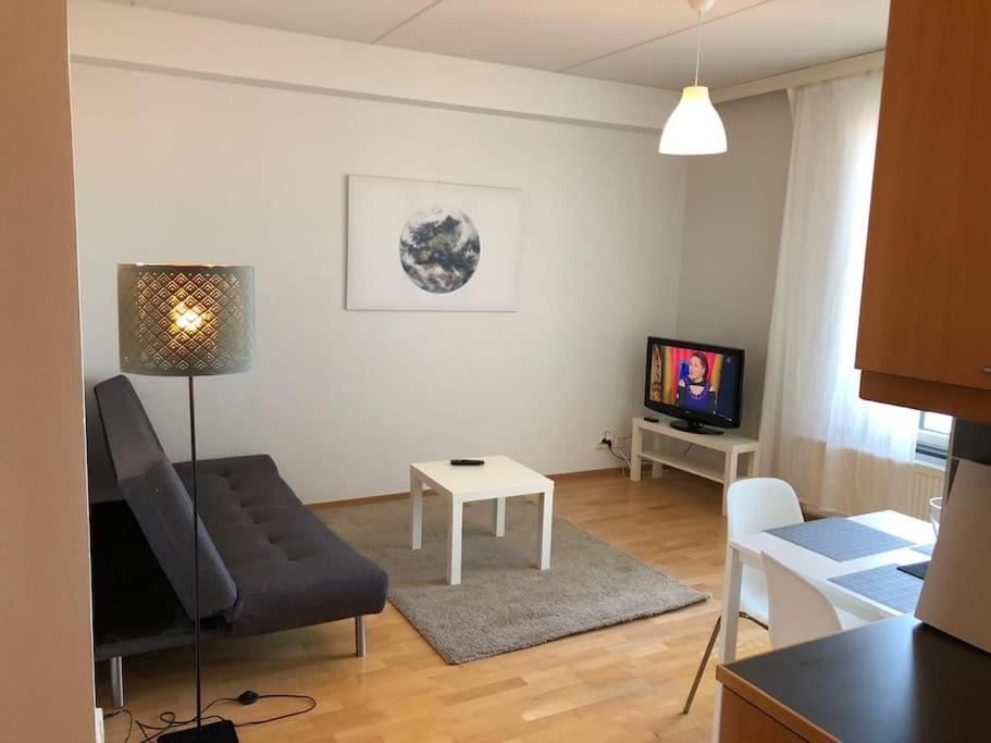 un soggiorno con divano e TV di Kotimaailma - Kaksio saunalla Herttoniemessä a Helsinki