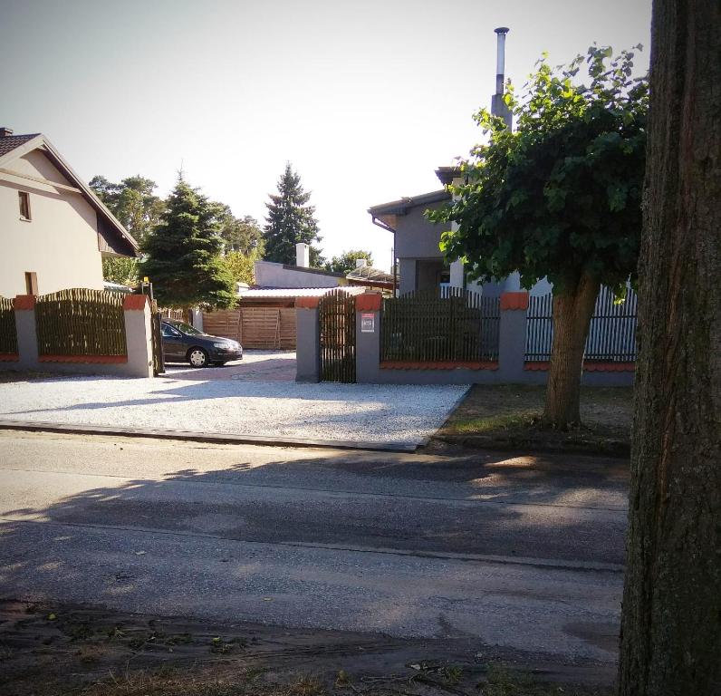 a street with a fence and a tree and a house at Noclegi Tuszyn M in Tuszyn