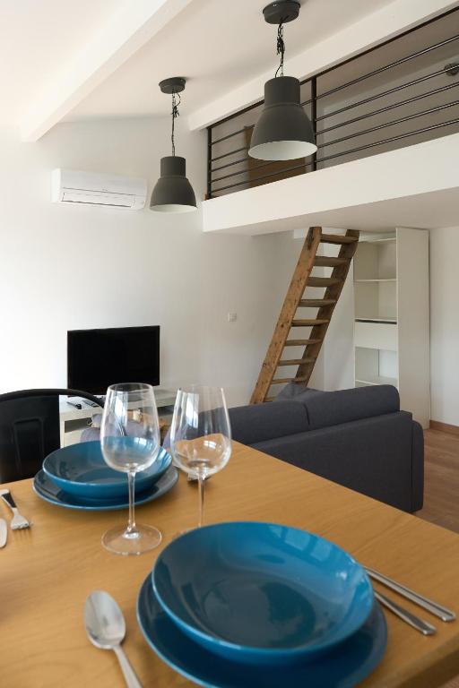 - une table à manger avec 2 verres à vin dans l'établissement vacance en bord de mer, à La Ciotat