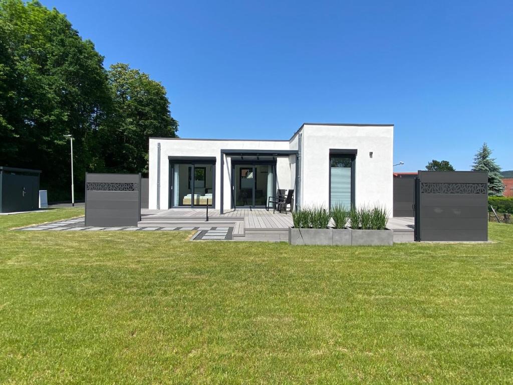 a white house with a green lawn in front of it at Ferienhaus Residenz am Stausee in Schotten