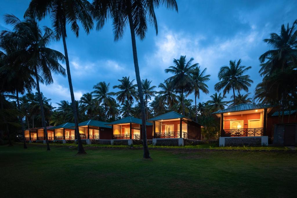 um resort com palmeiras ao fundo em Ibex River Resort, Pollachi em Coimbatore