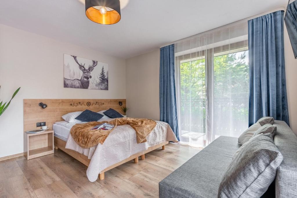 ein Schlafzimmer mit einem Bett und einer Couch in der Unterkunft Poza Szlakiem in Zakopane