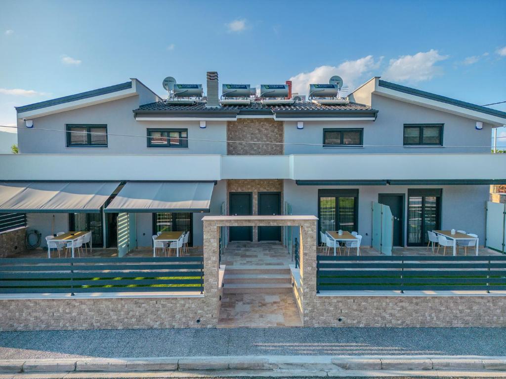 uma casa branca com mesas e cadeiras à sua frente em Dream Luxury Apartments em Stavros
